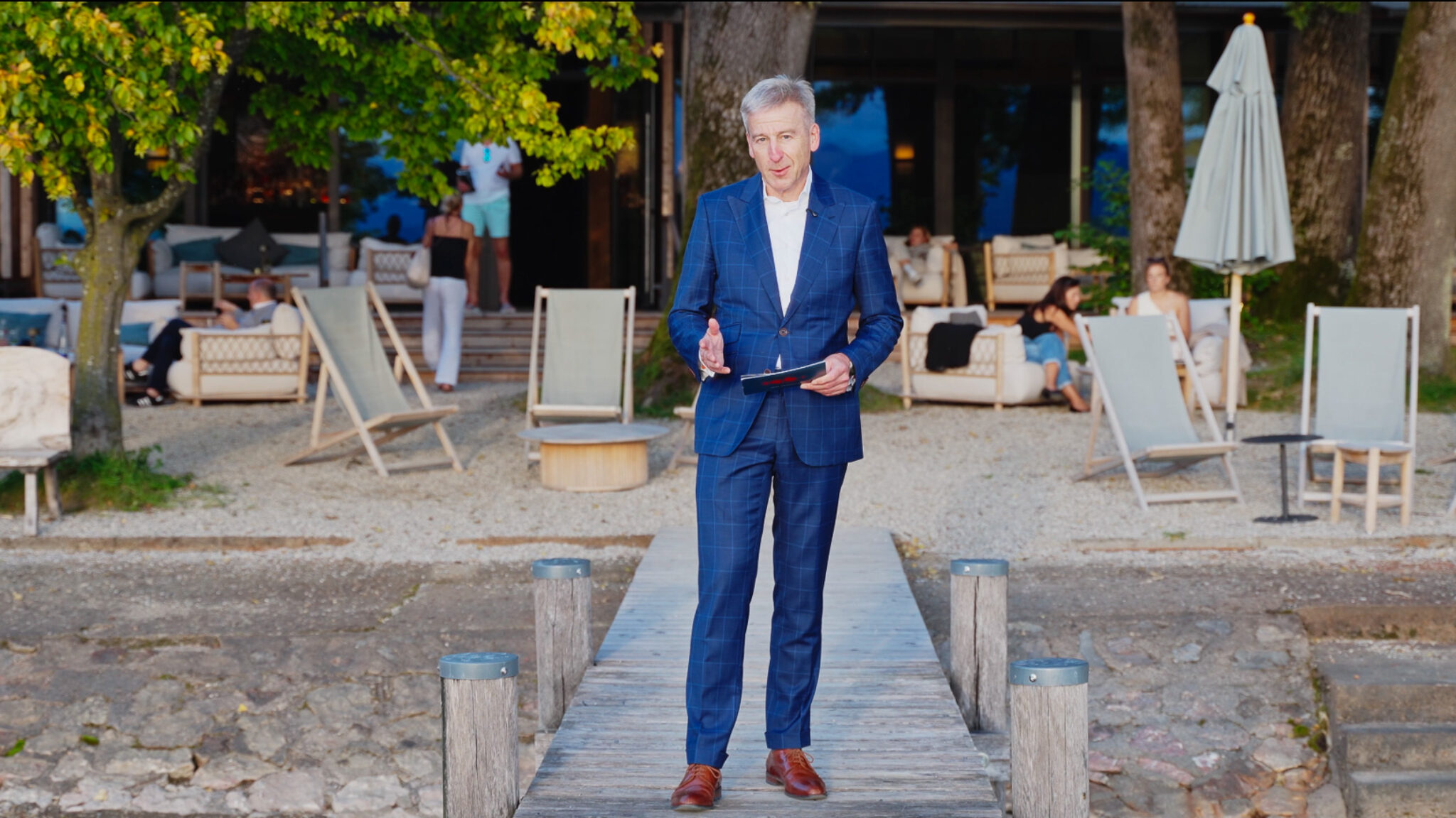 Professionelle Interview-Produktion von 4kFactory: Ein Speaker des 196+ Forums moderiert auf dem Steg des Chiemgauhofs am Chiemsee vor einer sommerlichen Event-Kulisse.