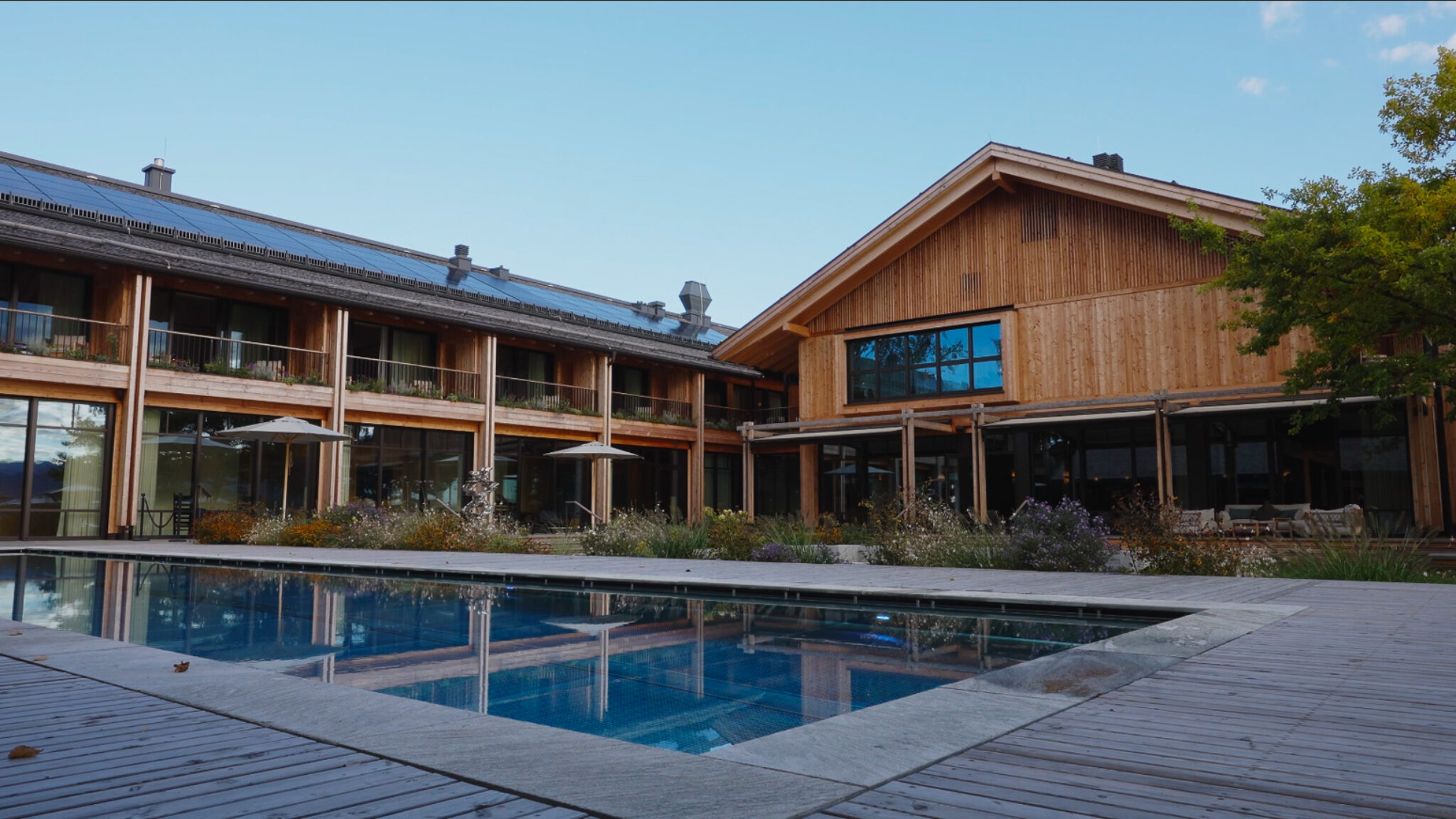 High-End Hospitality-Videografie für ein Werbevideo für Hotels: 4kFactory setzt die moderne Holzarchitektur und das Garten-Ambiente des Chiemgauhof Lakeside Retreats in Szene.