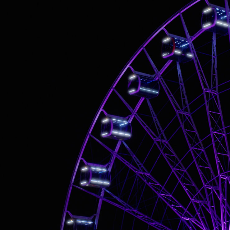 Detailaufnahme eines lila beleuchteten Riesenrads bei Nacht vor schwarzem Hintergrund – ein Highlight der Event-Videografie von 4kFactory. Die präzise Ausleuchtung der Gondeln unterstreicht die visuelle Qualität der Videoproduktion für das Avantgard Event im Werksviertel München.