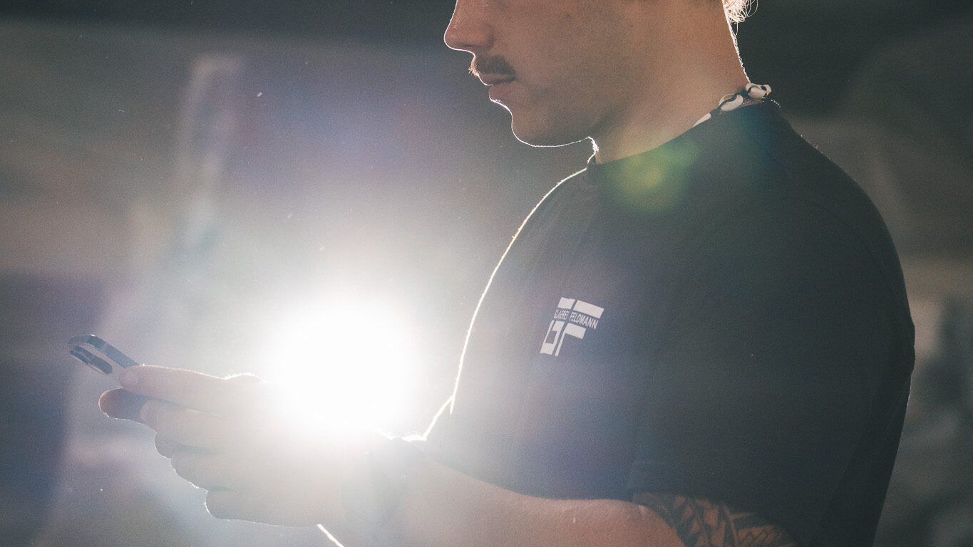 alt="Nahaufnahme eines Mitarbeiters der Glaserei Feldmann am Filmset. Die atmosphärische Gegenlichtaufnahme von 4kFactory zeigt die Konzentration während der Produktion in Nürnberg."