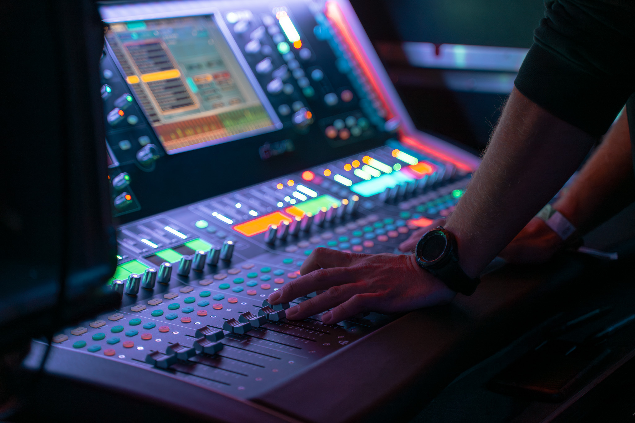 Professionelle Audio-Produktion von 4kFactory: Detailaufnahme eines Tontechnikers bei der präzisen Steuerung der Fader am Allen & Heath dLive Mischpult während des Grand Jam Events im Eintracht Frankfurt Stadion.