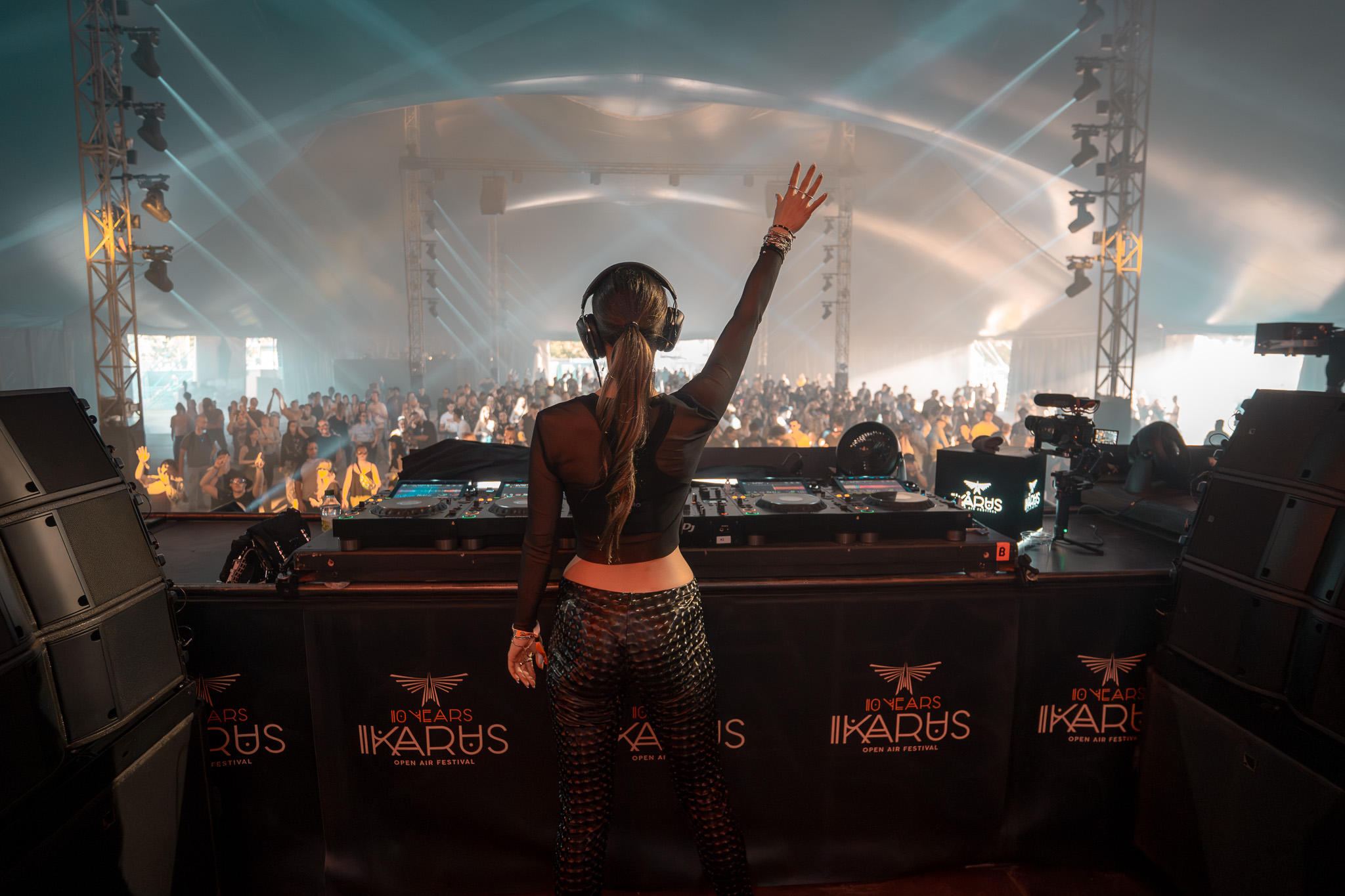 alt="Lauren Mia interagiert mit der Menge auf dem Ikarus Festival 2025. Der Blick von der Bühne zeigt die feiernde Crowd, dokumentiert von 4kFactory."