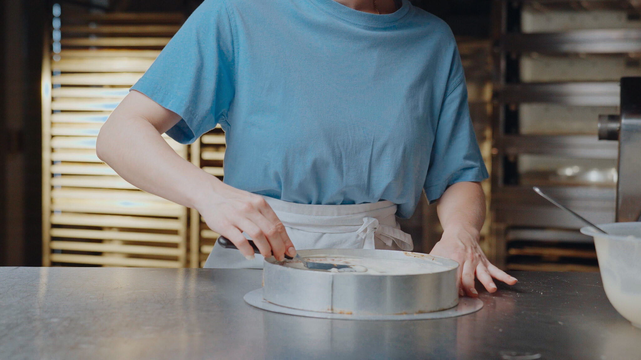 Cineastische Food-Videoproduktion von 4kFactory: Detailaufnahme beim präzisen Einstreichen einer Torte in der Backstube von Krümel und Korn.