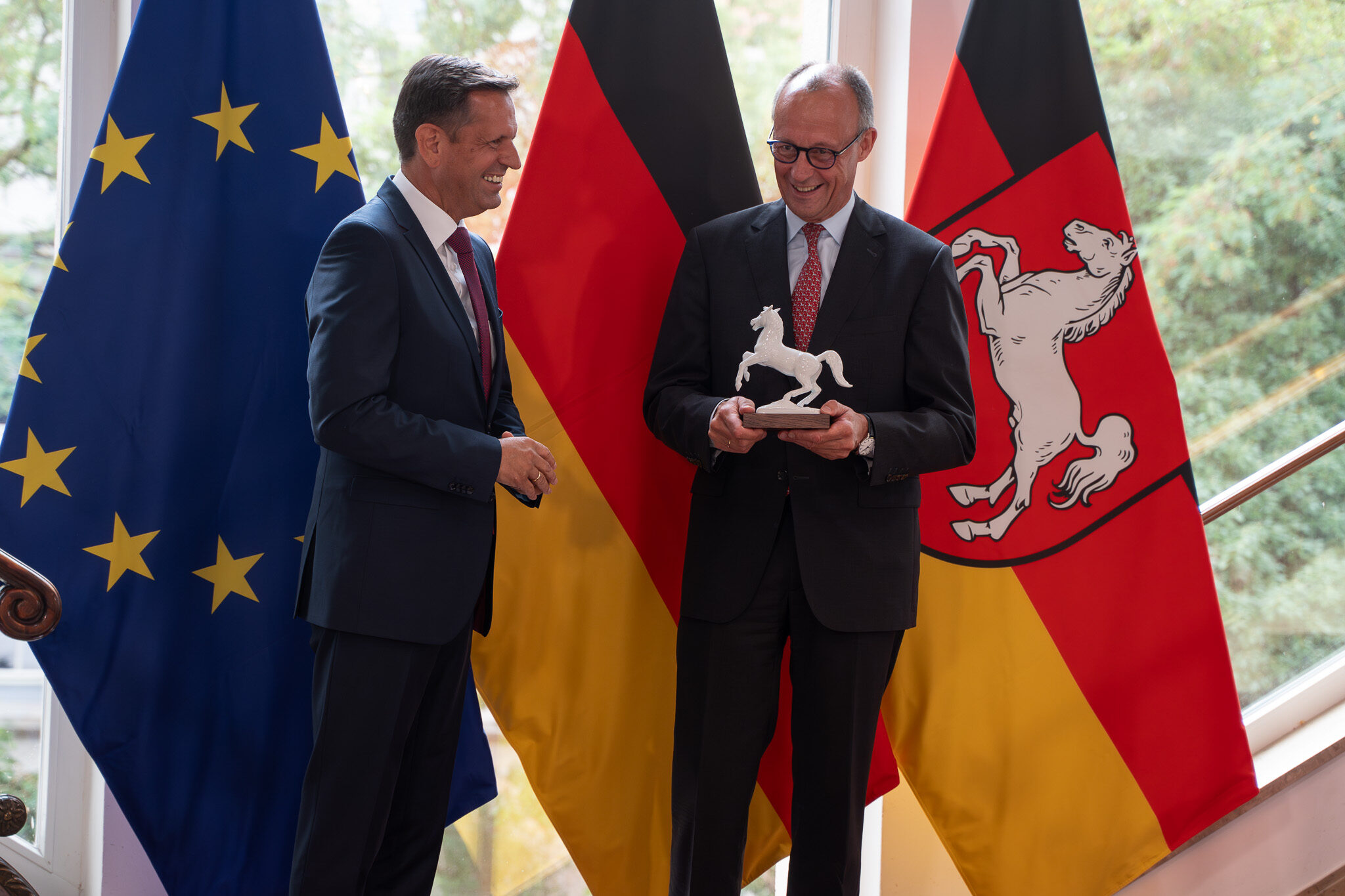 Staatstermin in Hannover: Bundeskanzler Friedrich Merz und Ministerpräsident Olaf Lies mit dem Niedersachsen-Ross vor der Landesflagge, dokumentiert von 4kFactory für ein Automotiv Werbevideo.