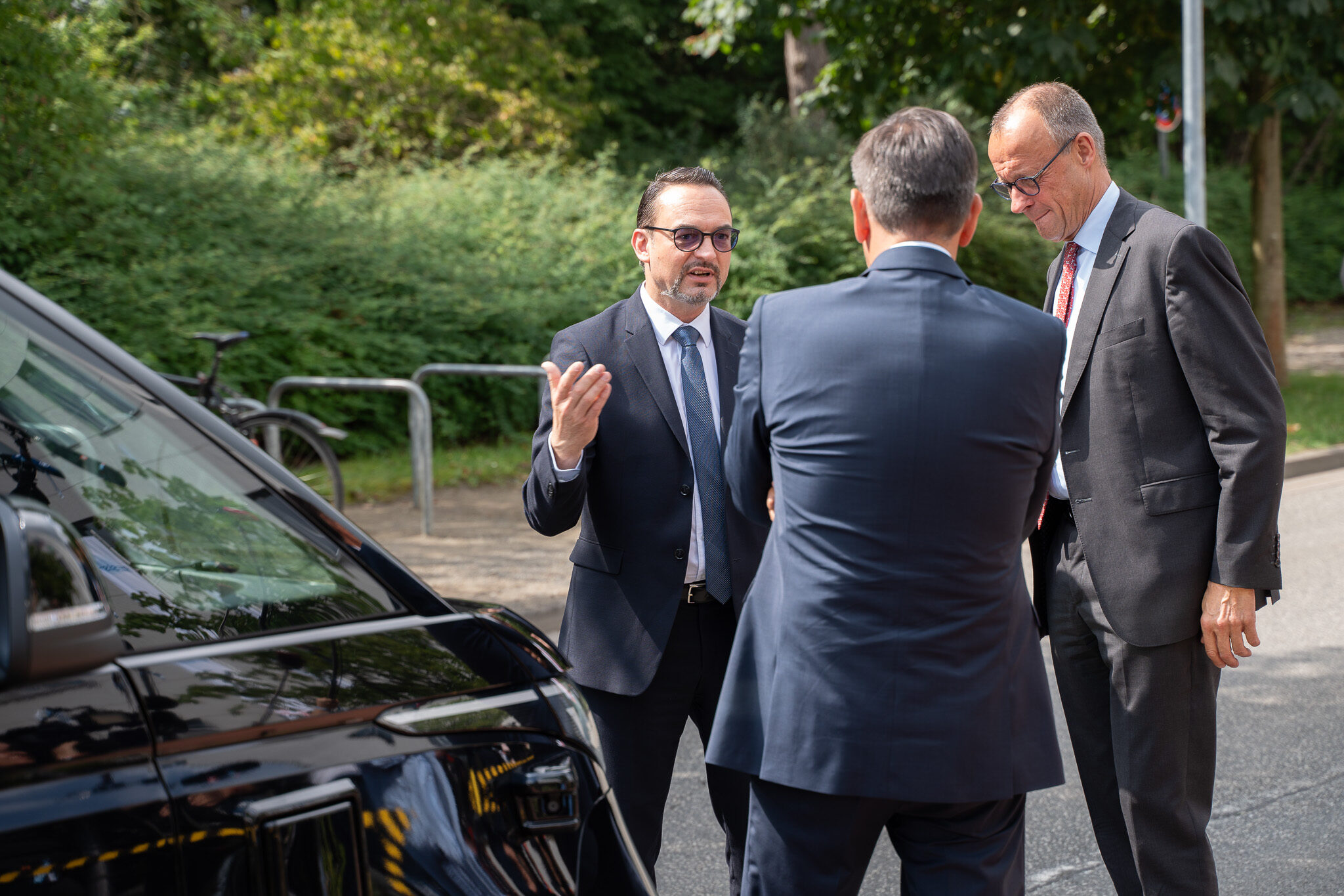 Professionelles Media Asset von 4kFactory für ein Automotiv Werbevideo : Offizieller Termin mit Bundeskanzler Friedrich Merz und der MOIA Geschäftsführung zur autonomen Mobilität. Sie stehen neben einem autonomen VW ID Buzz