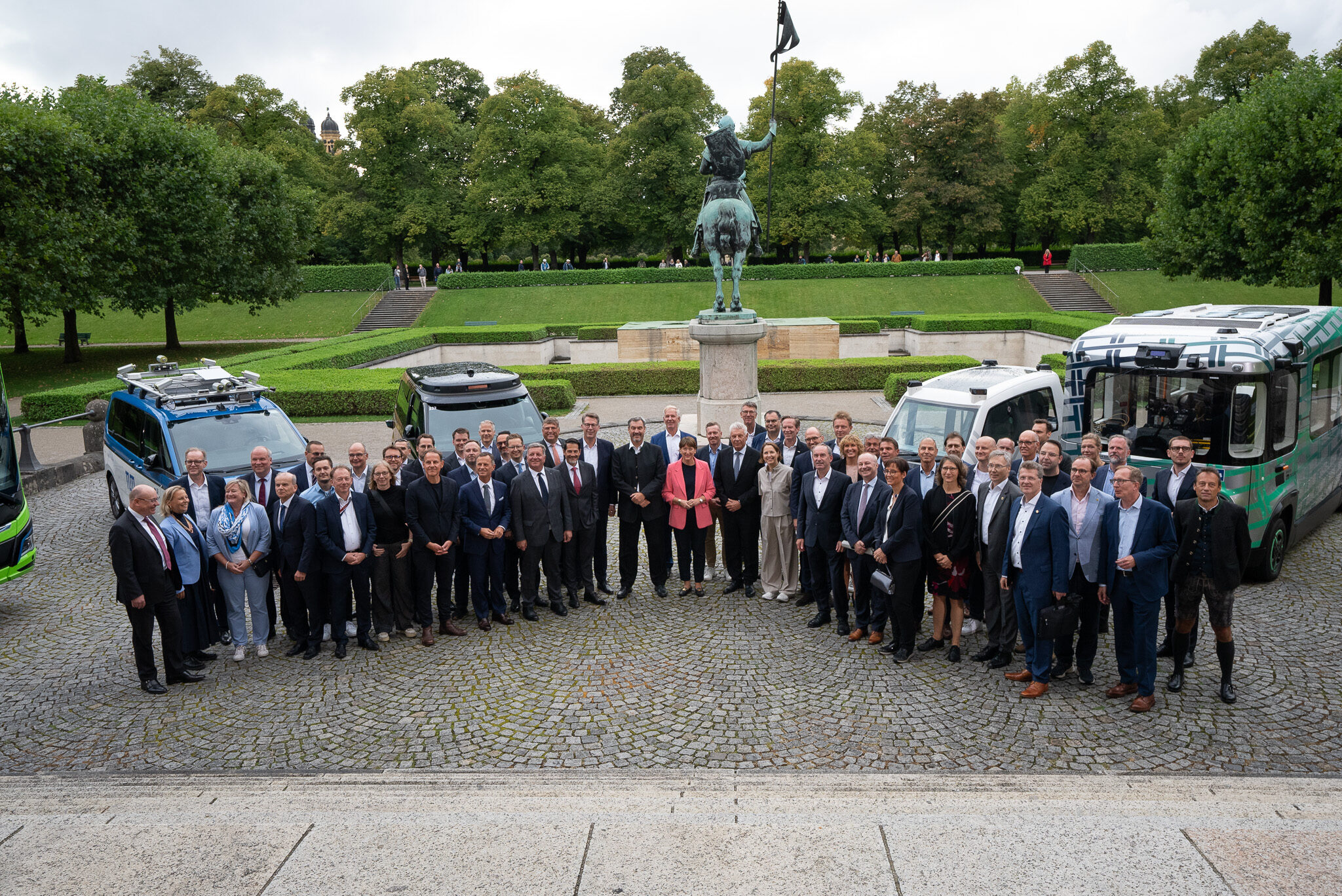 Hochkarätiges Delegationsfoto in der Bayerischen Staatskanzlei: Ministerpräsident Markus Söder mit Vertretern der Automobilindustrie und autonomen Testfahrzeugen, dokumentiert und festgehalten in Automotiv Social Media Content von 4kFactory.