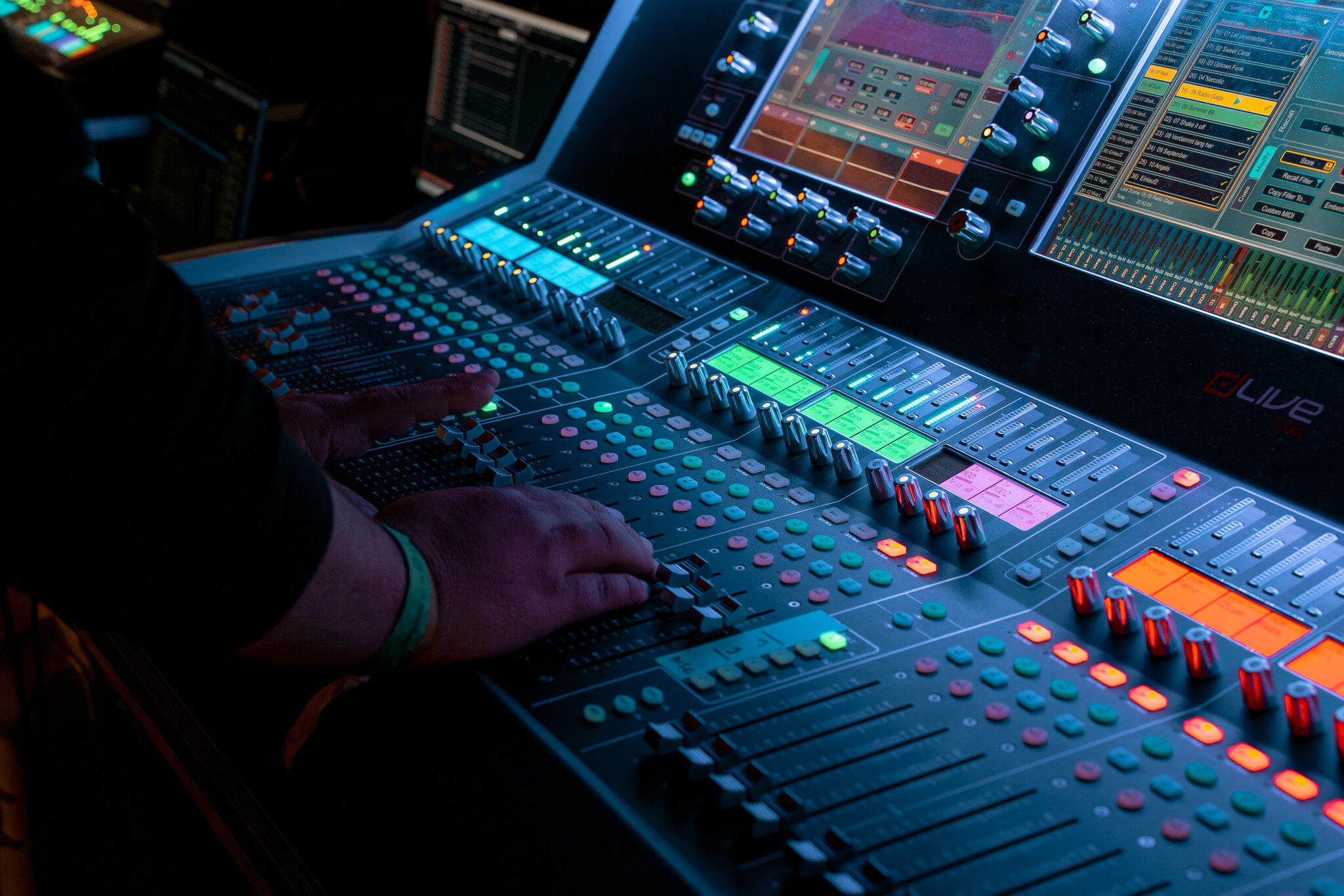 Professionelles Werbevideo für Audio Technica von 4kFactory: Detailaufnahme der Hände eines Tontechnikers an den Fadern eines Allen & Heath dLive Mischpults während des Grand Jam Events im Eintracht Frankfurt Stadion.