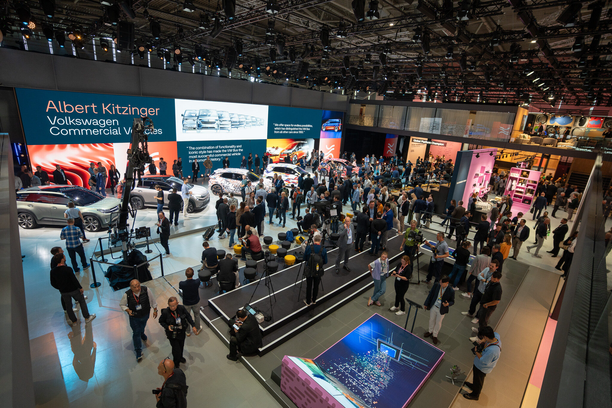 Umfassende Event-Dokumentation sowie Automotiv Social Media Content von 4kFactory: Blick von oben auf den großzügig gestalteten Volkswagen Commercial Vehicles Stand bei der IAA MOBILITY, inklusive LED-Präsentationsflächen und Fahrzeugeponaten.