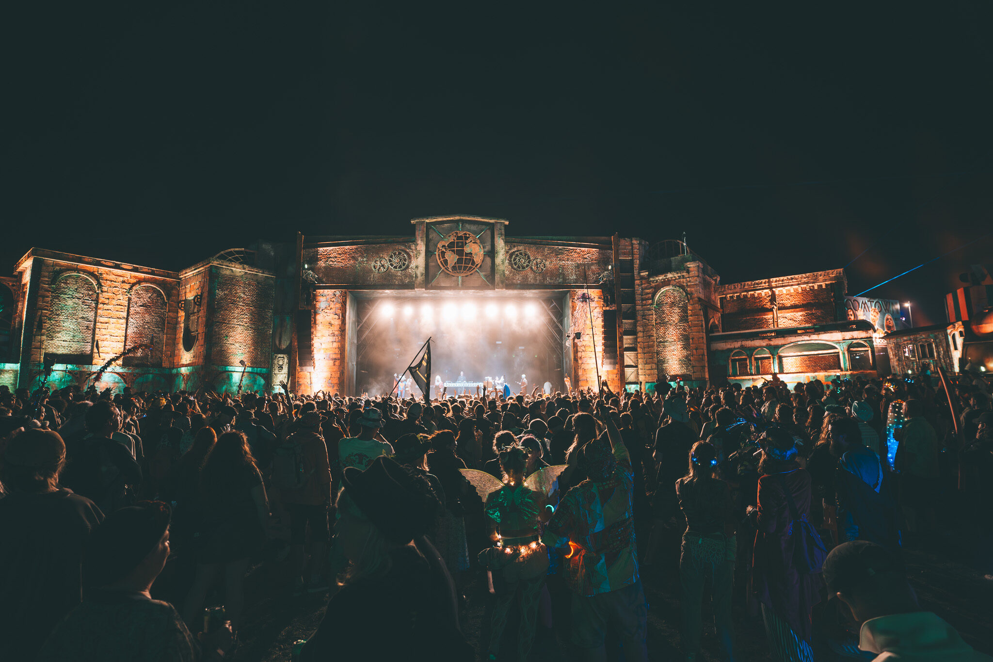 Großformatige Event-Videografie: Beeindruckende Panorama-Aufnahme des gesamten Boomtown Festivalgeländes mit Fokus auf die Cameo Lichtinszenierung.