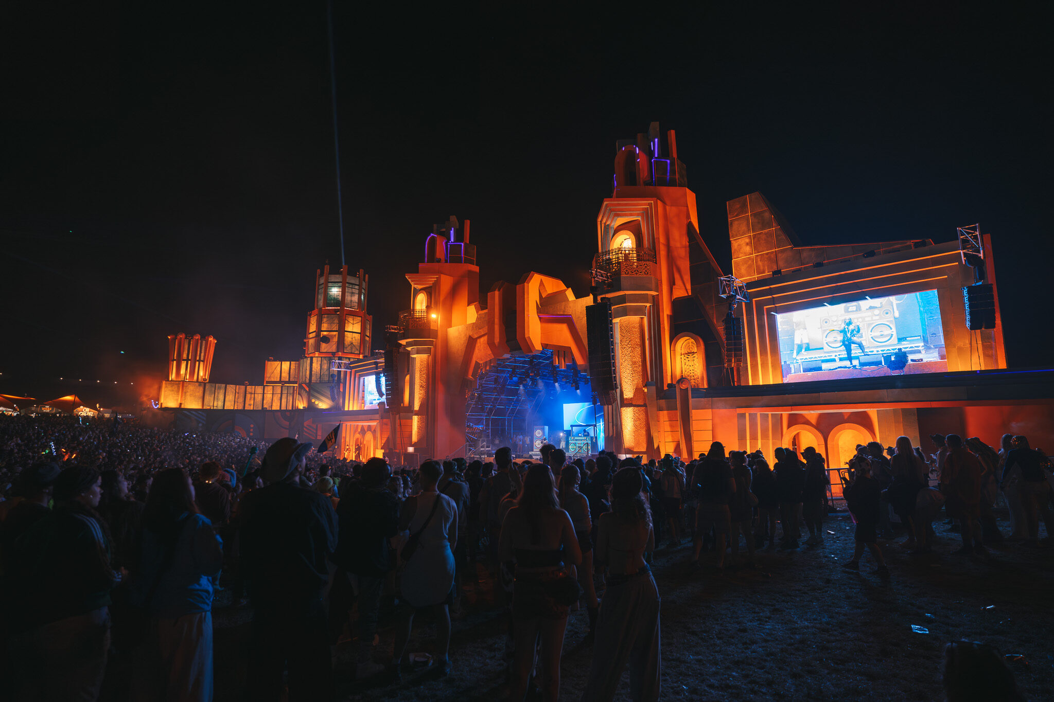 Spektakuläre Event-Videografie: Weitwinkel-Aufnahme des Boomtown Festivals bei Nacht mit der von Cameo illuminierten Mainstage-Architektur.