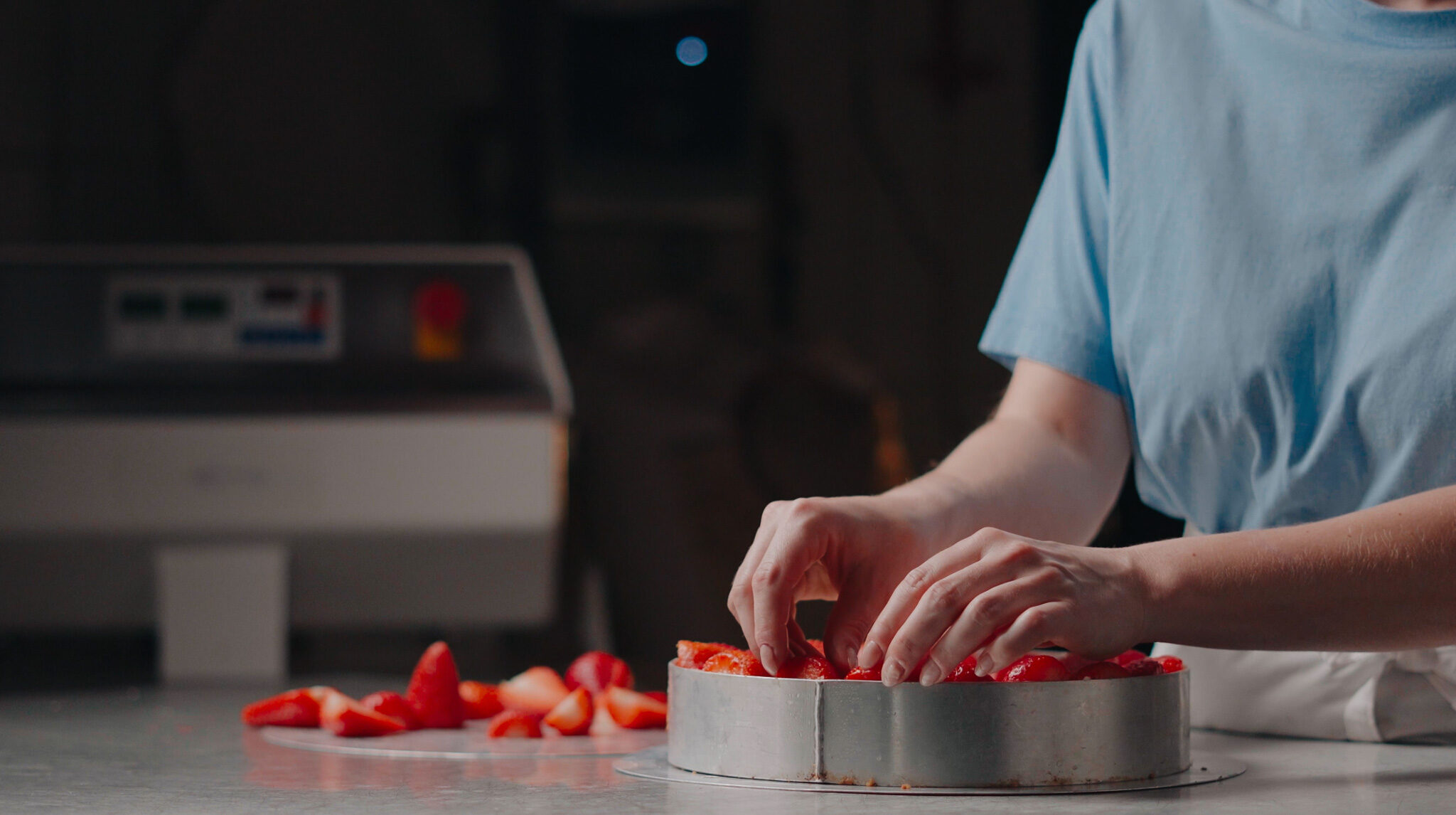 Cineastische Food-Produktion von 4kFactory: Detailaufnahme beim kunstvollen Belegen eines frischen Erdbeerkuchens bei Krümel und Korn.